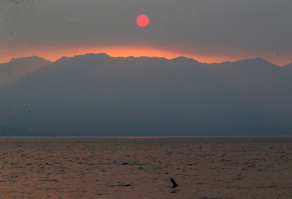 A smoky sunset is seen over Lake Tahoe in this view from Lakeside Beach in South Lake Tahoe