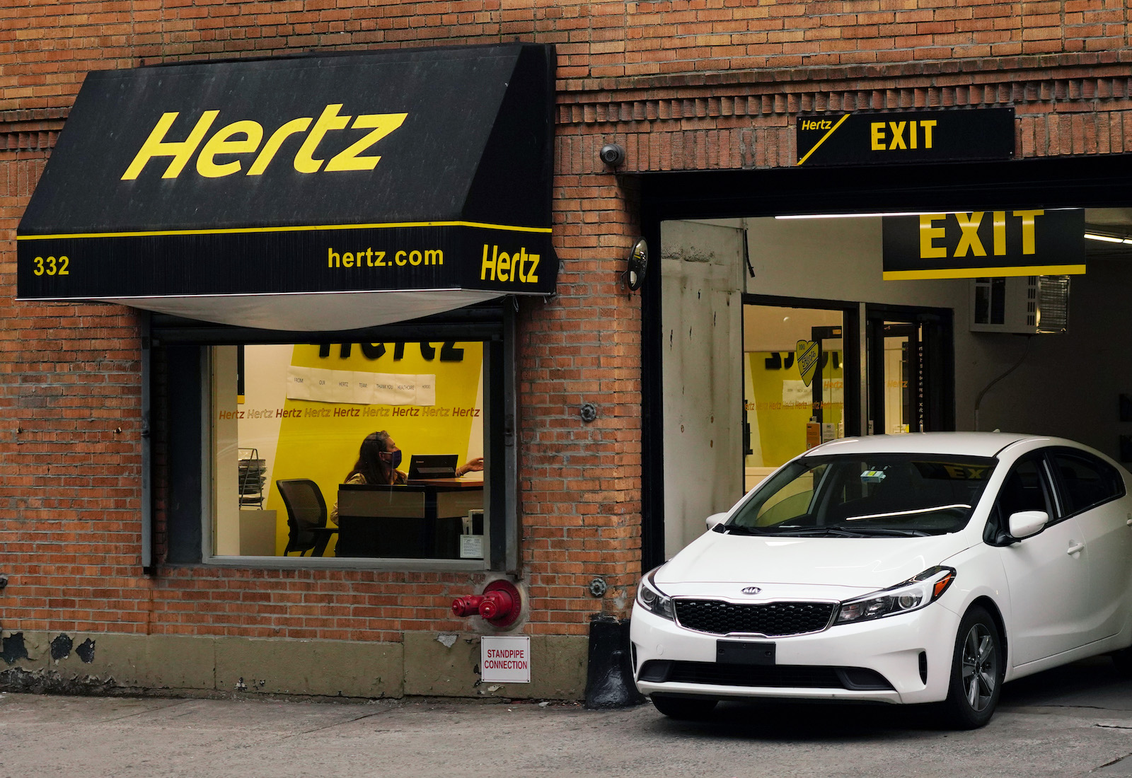 A car emerges from a Hertz garage