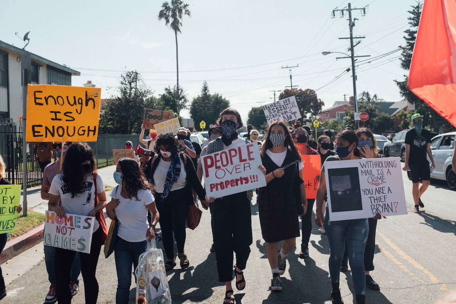 a group of people with signs marching down the middle of a street