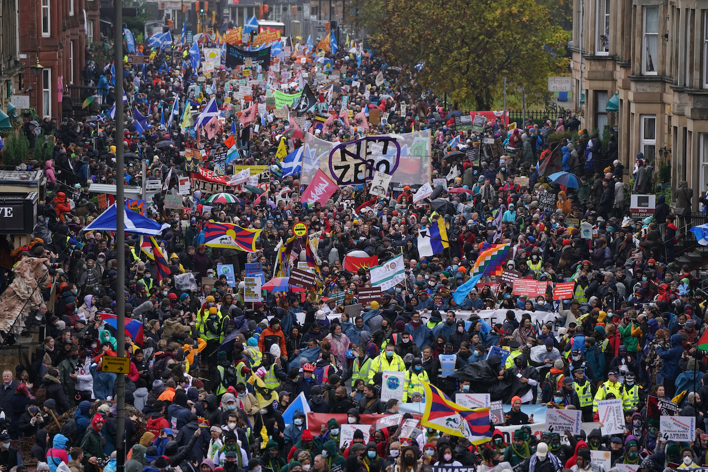 a wall of protesters fill a city street in Glasgow