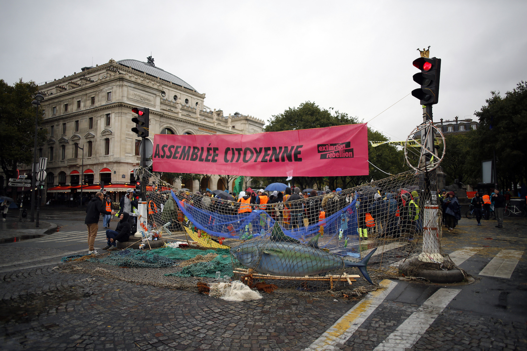 a large pink banner and a group of portesters with a giant fake fish prop