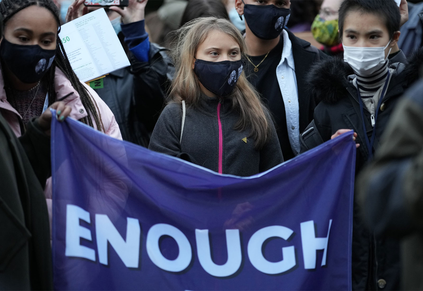 Climate activist Greta Thunberg at COP 26 holding a flag that reads 