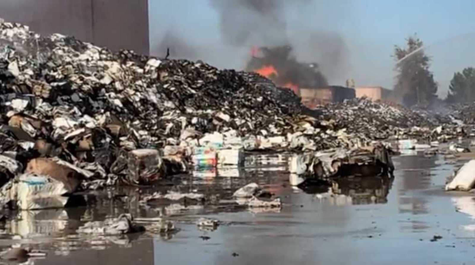 A fire smolders at a commercial distribution center on Oct. 1, 2021, in Carson, Calif.