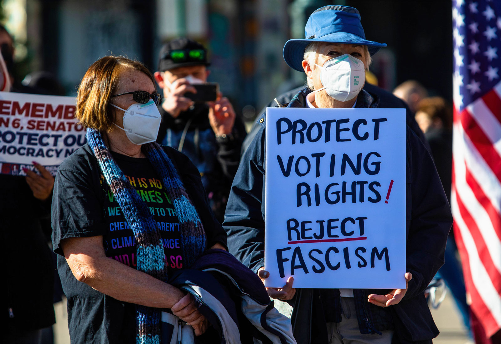 Protesters and a sign reading "protect voting rights! reject racism"