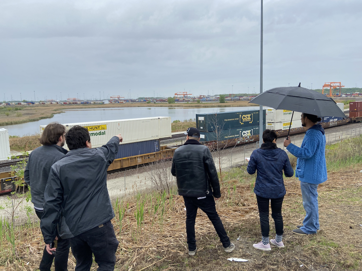 a group of people point at shipping containers