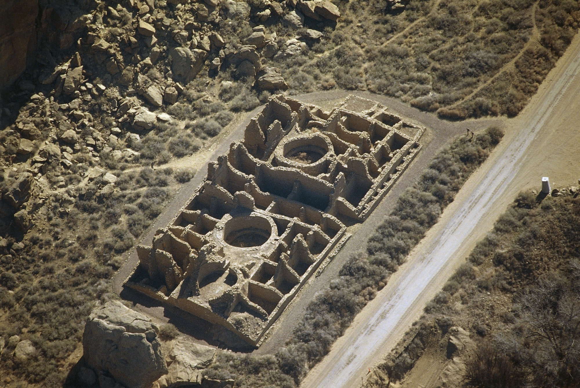 stone structure with large circles and smaller stone square walls in desert canyon setting