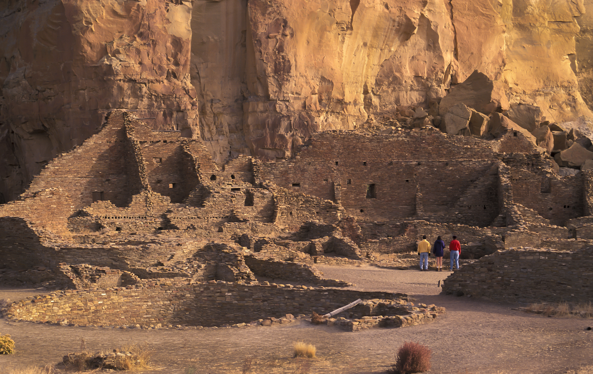 large brown stone structure made of bricks in the middle of a brown-red canyon