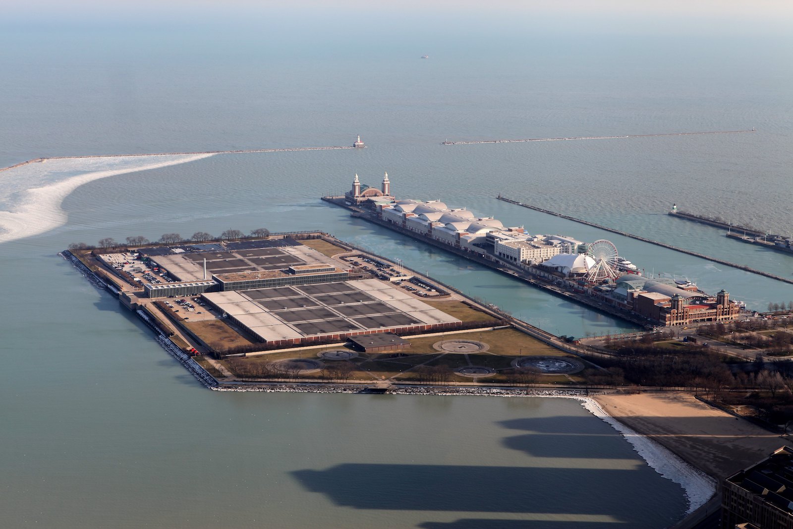 an aerial view of a piece of land with industrial equipment jutting into the water