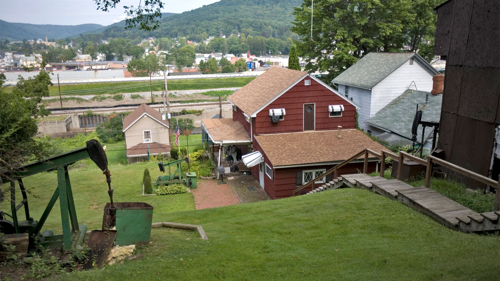 House with an old oil pumpjack in back yard