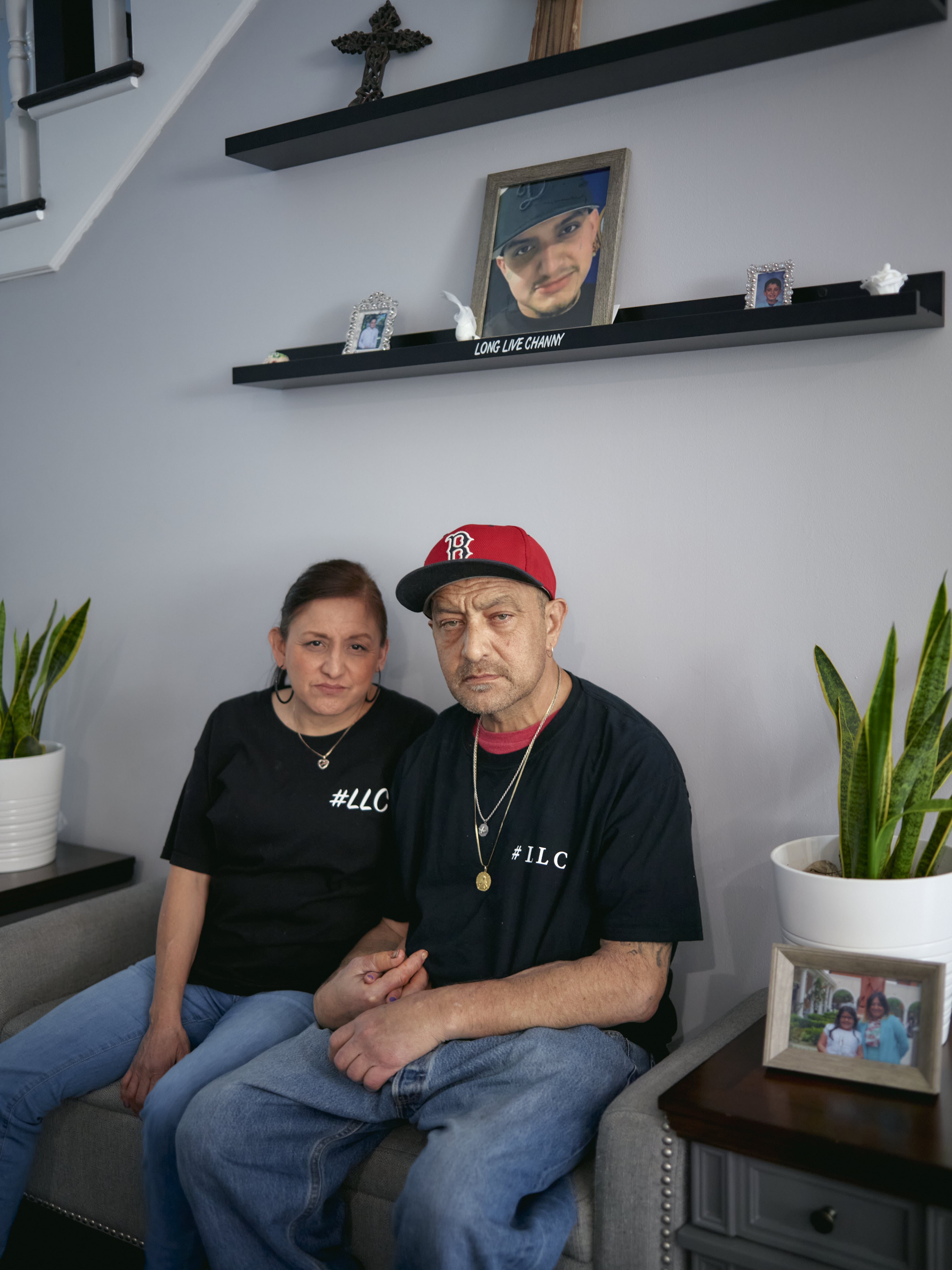 a man and a woman sit wearing black t-shirts that say #LLC for long live channy