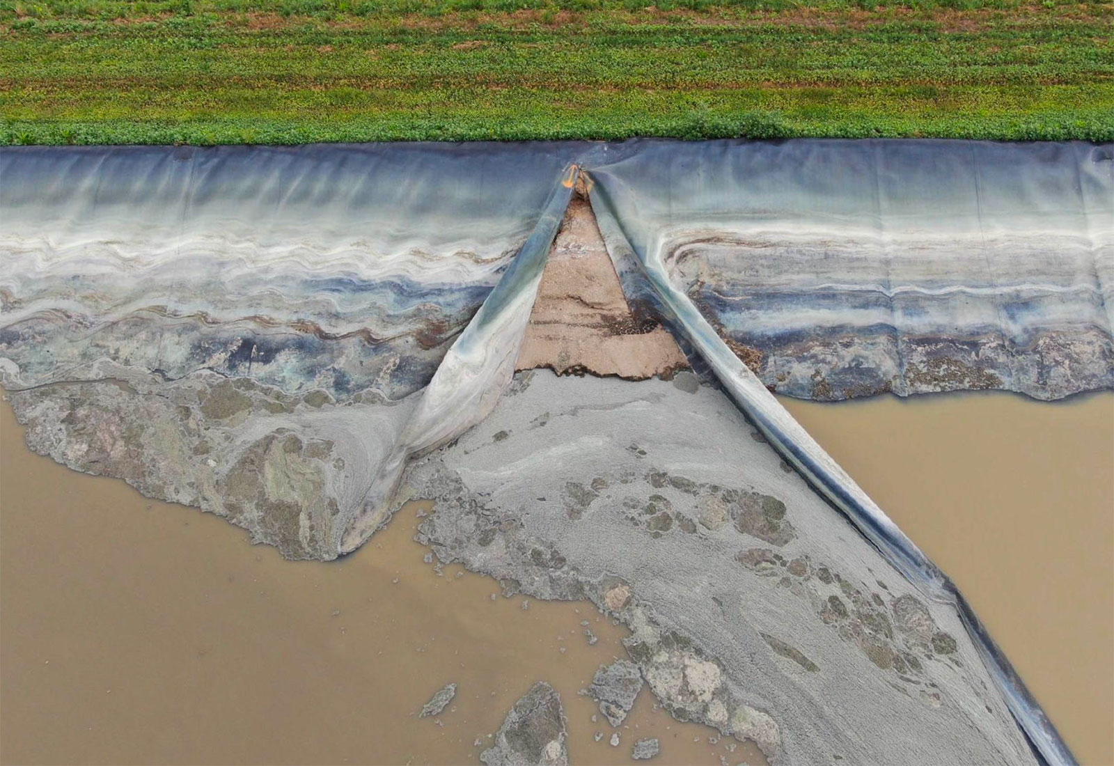 Aerial view showing a tear in a containment lagoon liner