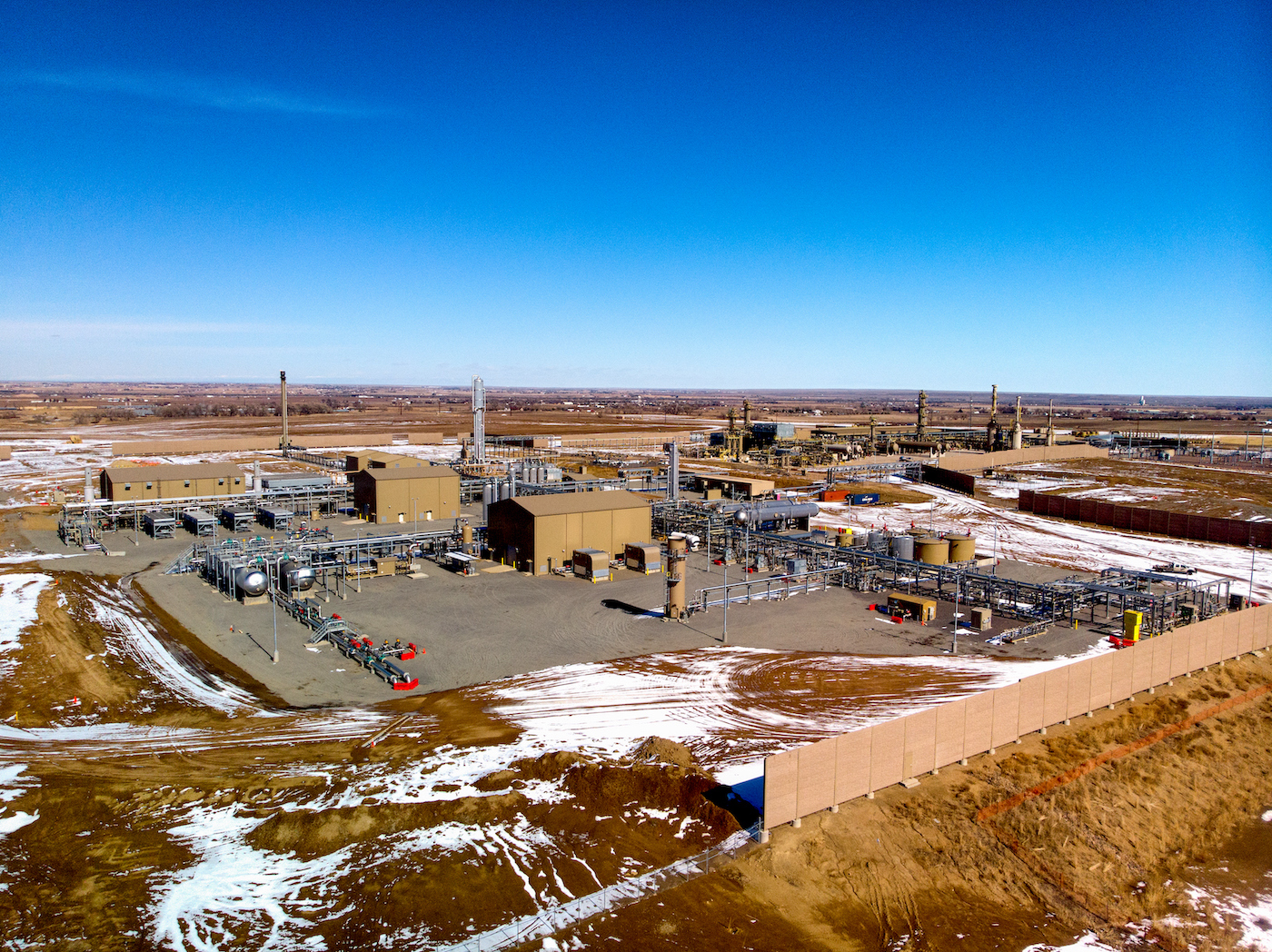 Aerial view of a fracking drilling rig with snow on the ground