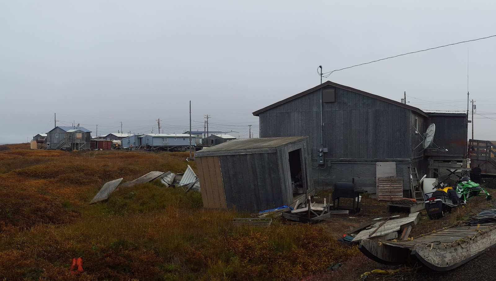 a wooden building tilts into the brown earth