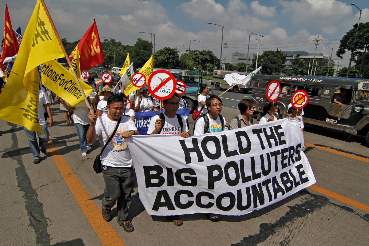 Six people march while holding a sign that says 