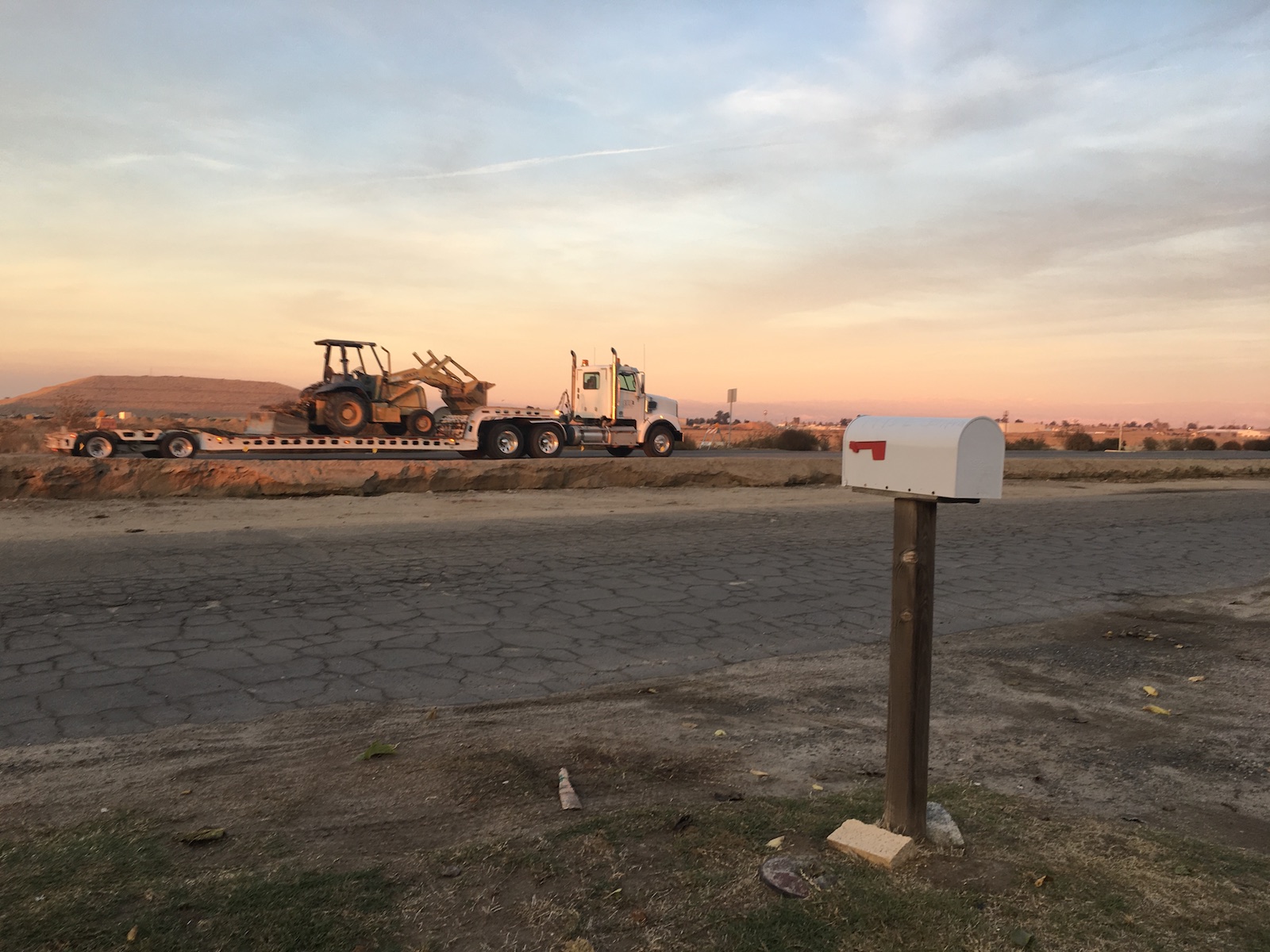 construction equipment across the street from a white mailbox