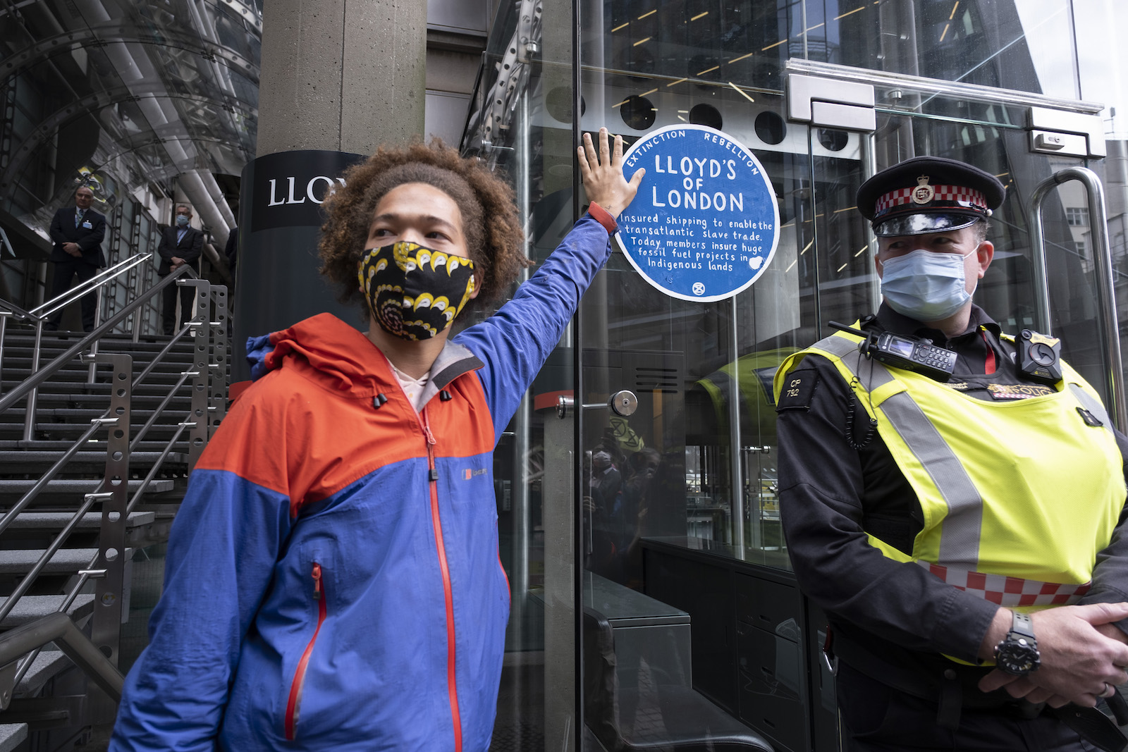 a person puts their hand on a blue sticker on a glass window