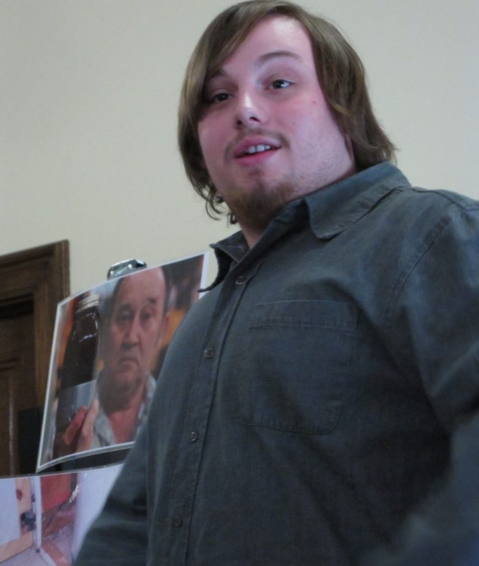 a man in a button up shirt walks by a sign