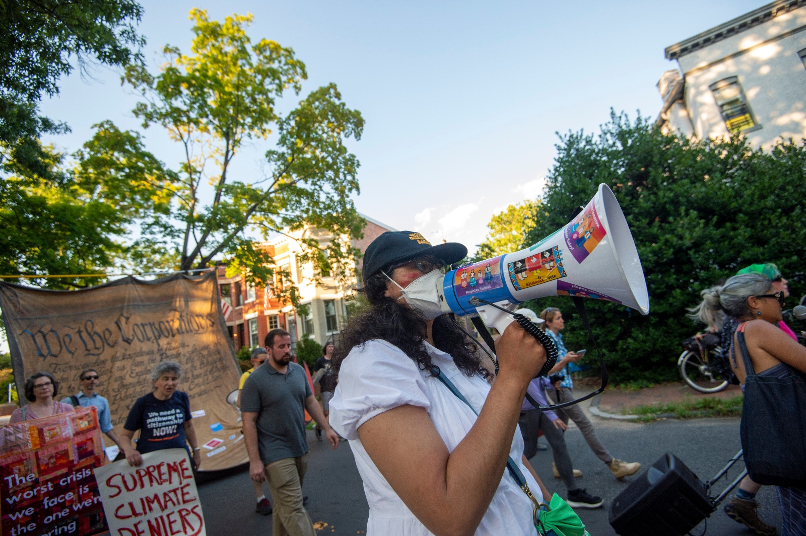 A street protest with signs reading We the corporations and Supreme Climate Deniers