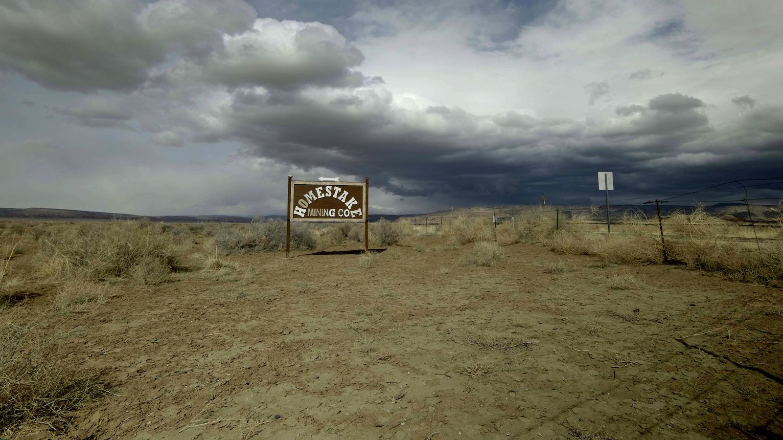 A brown sign demarcating the Homestake mine, surrounded by plains.