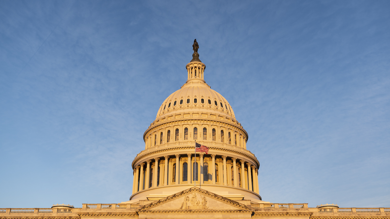 the United States Capital building is washed in sunlight against a blue sky