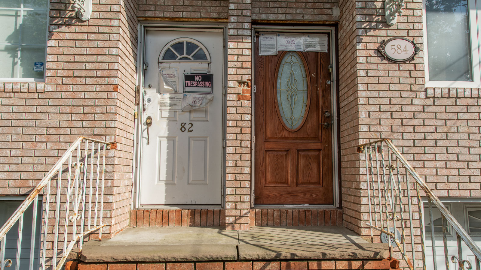 two doors in a brick row house with no trespassing signs