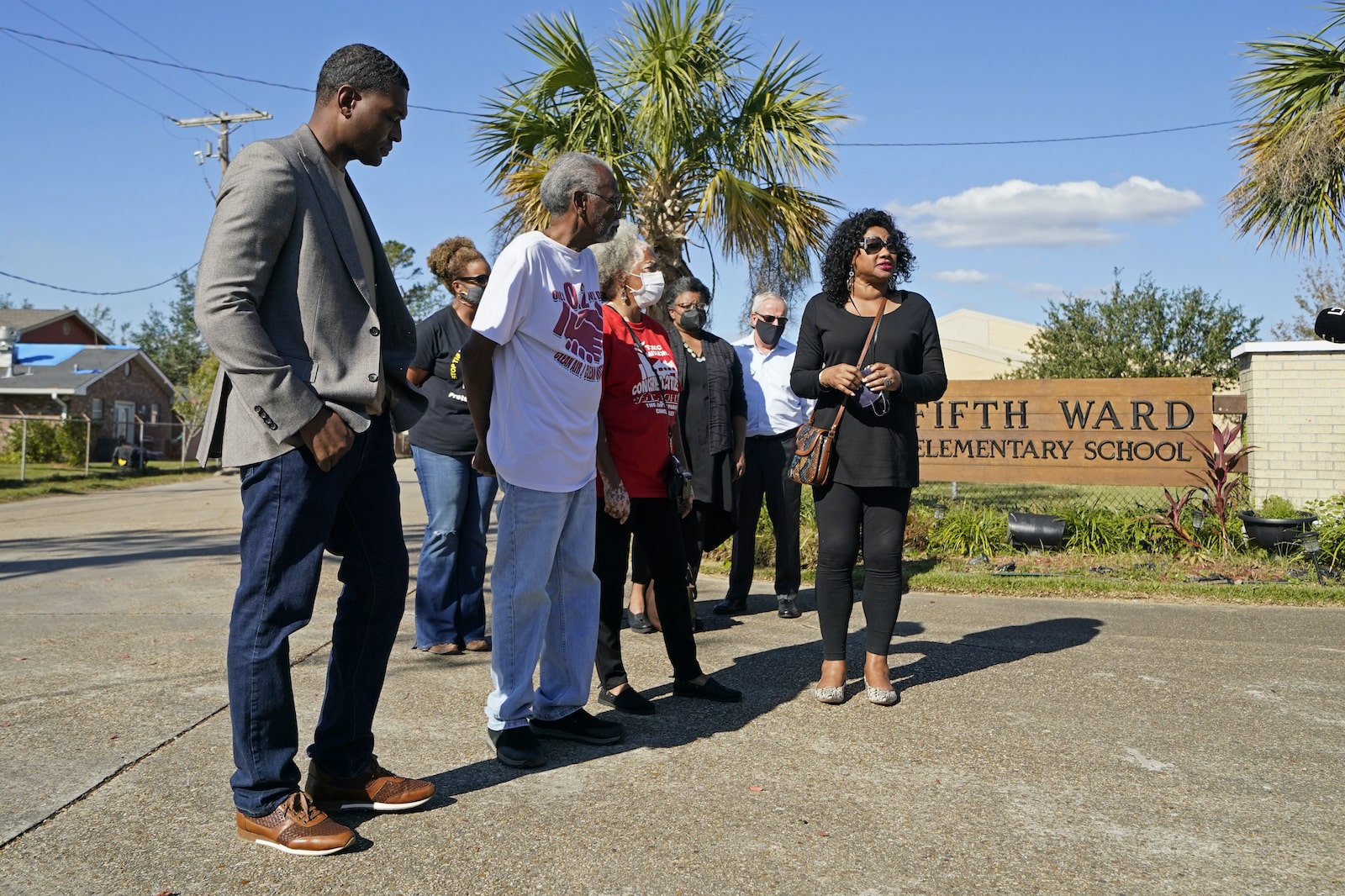 a group of people stand in front of a school