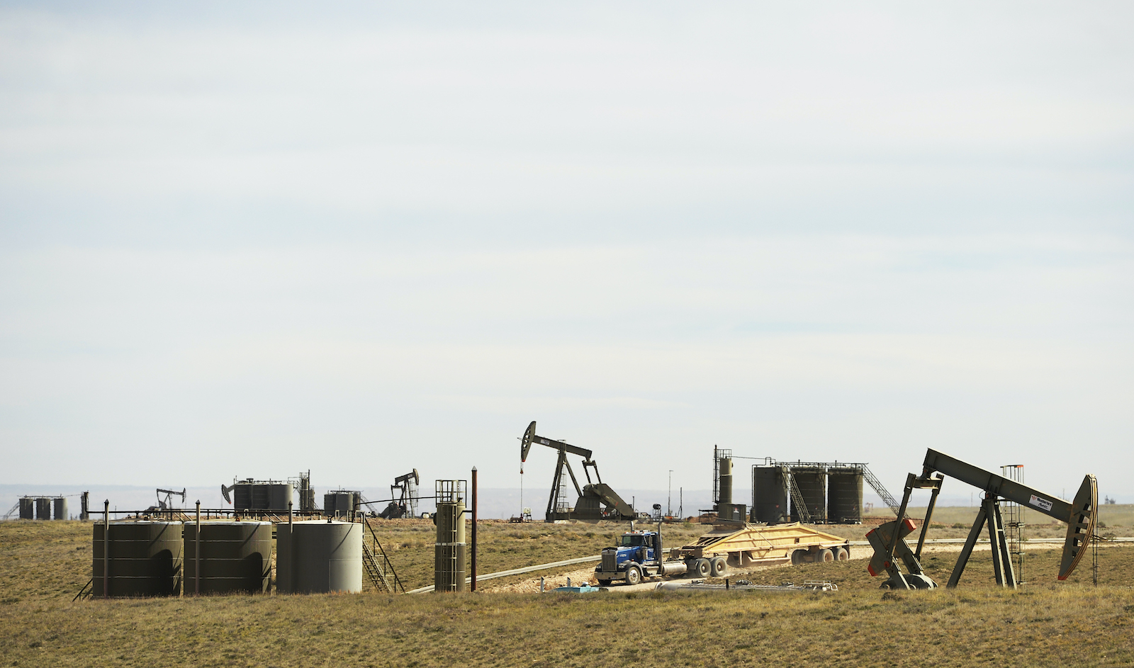 a pumpjack under a wide blue sky