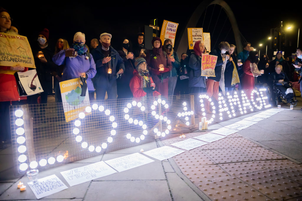 Lit up "loss and damage" sign at protest.