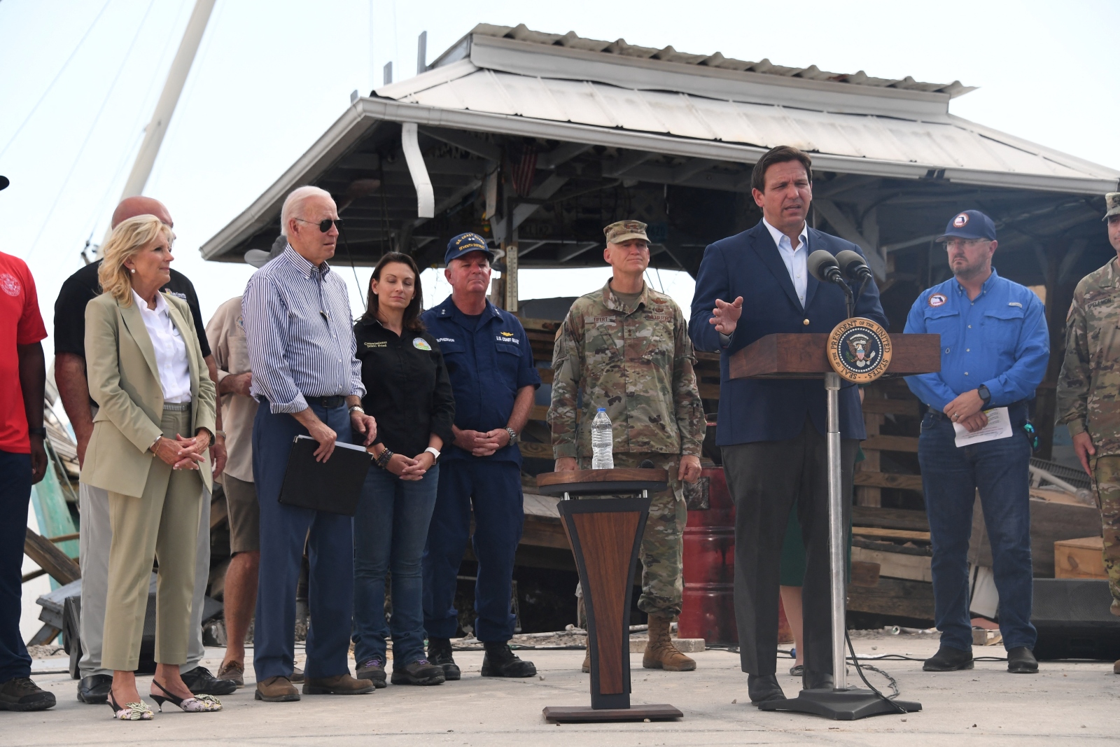 President Joe Biden and First Lady Jill Biden listen to Florida Governor Ron DeSantis speak in Fort Myers, Florida.