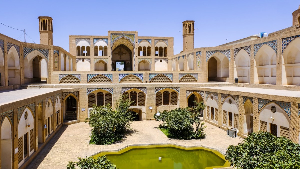 Two wind towers are visible from the inner courtyard of a mosque in Iran.