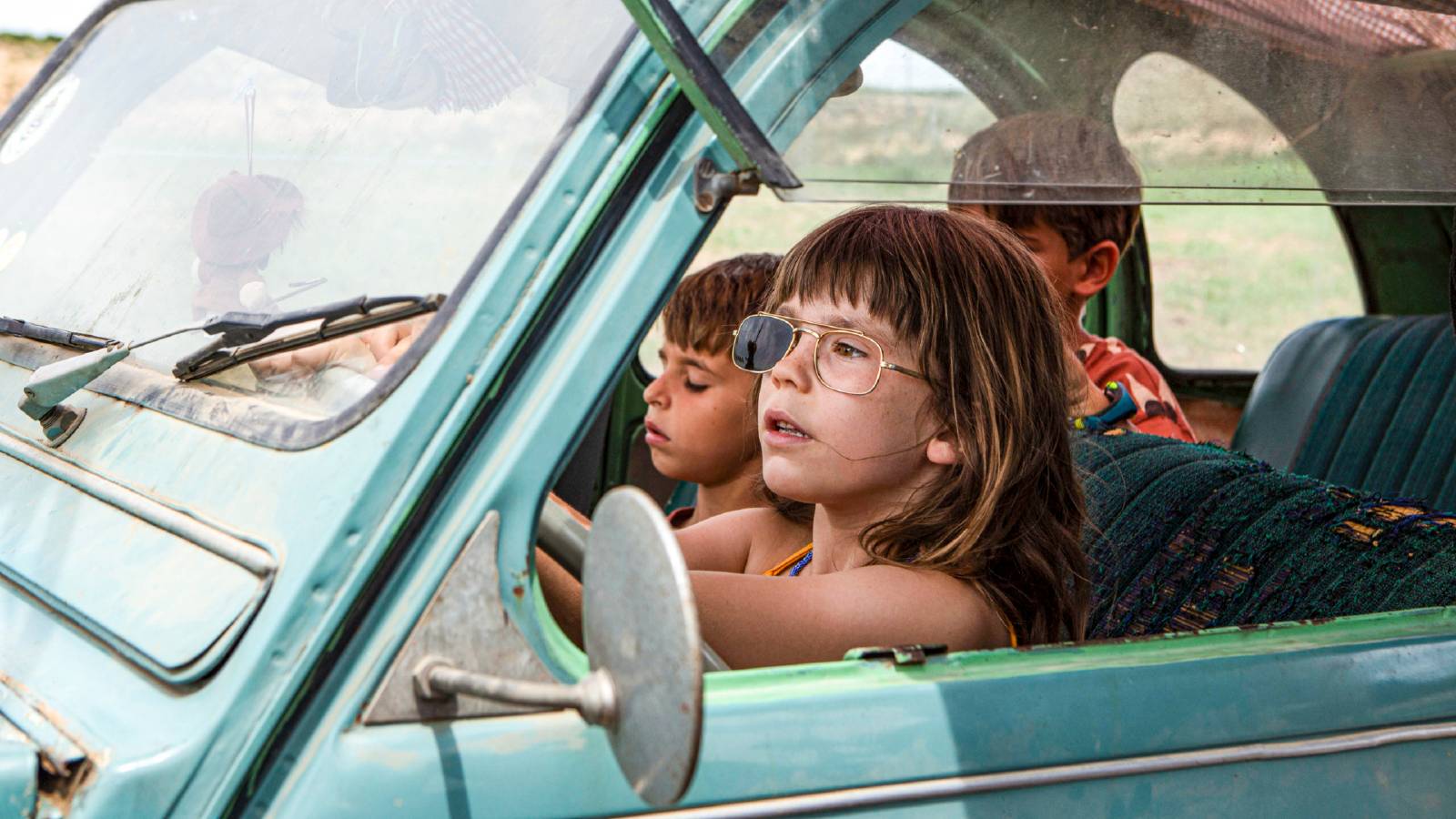 Children play in an abandoned car