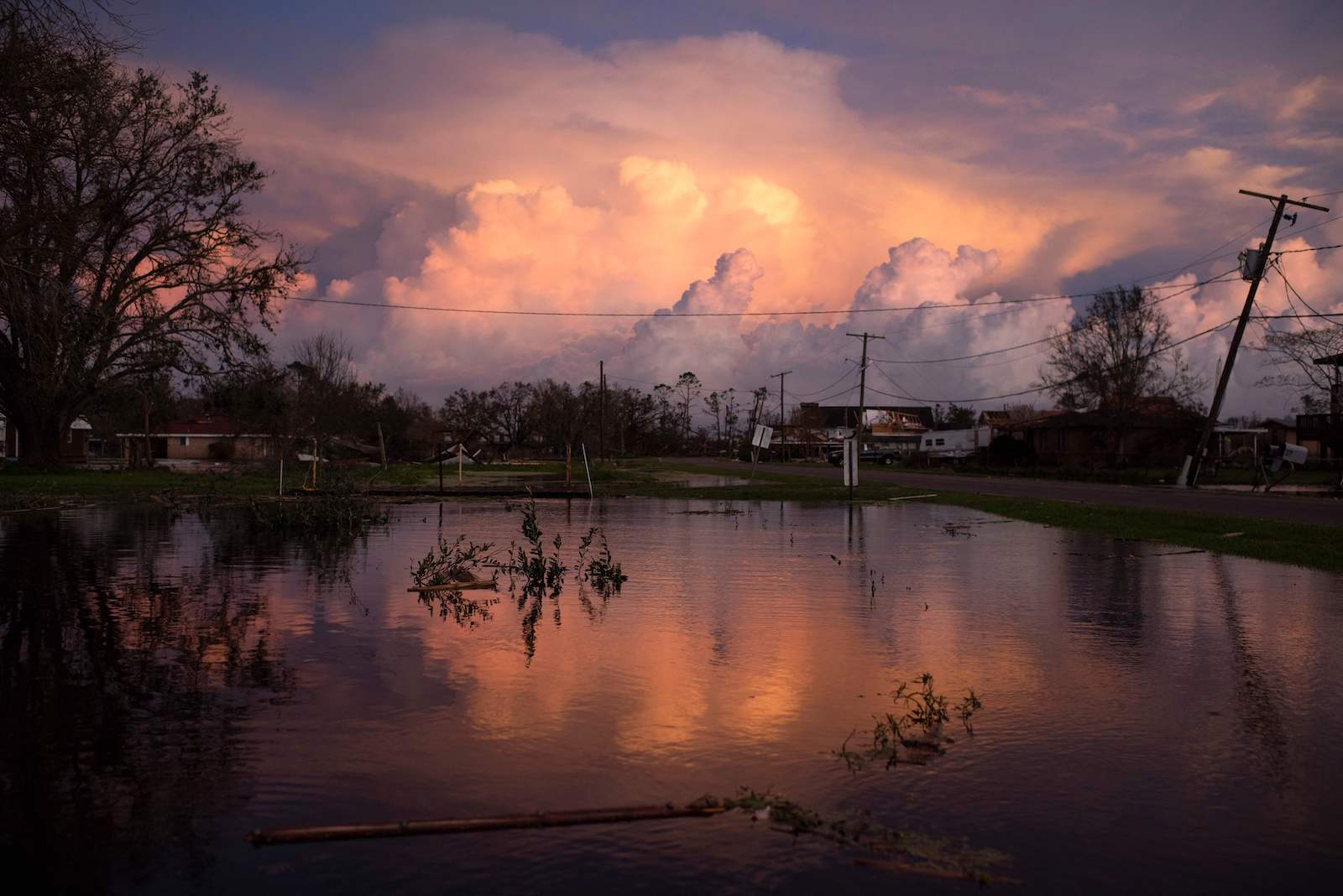 clouds in the sky over a lake lined with houses