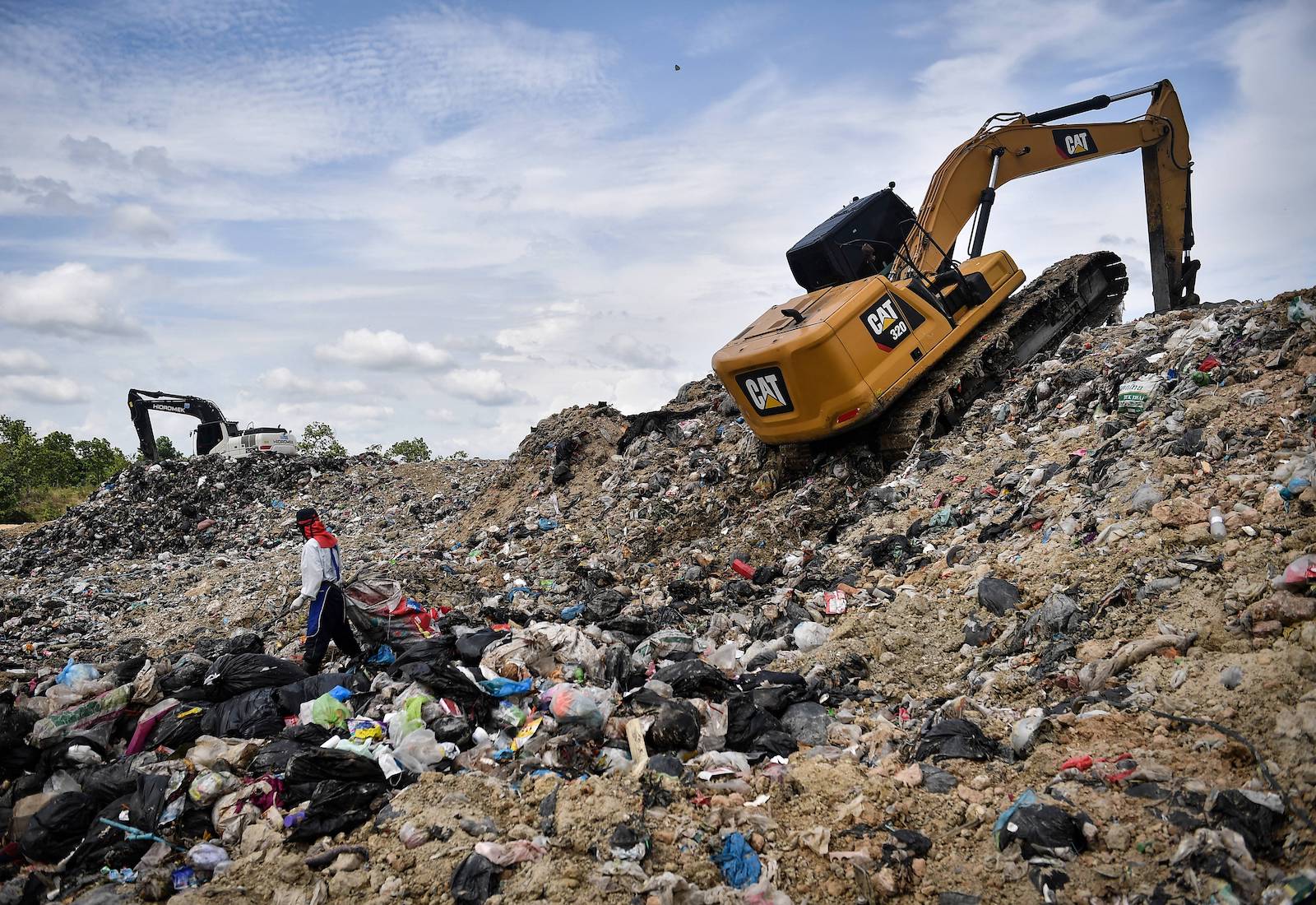 Person and bulldozer at a landfill