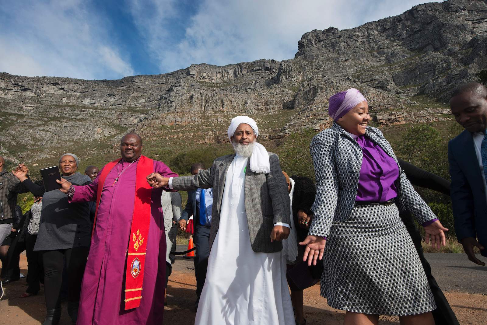 a group of people in religious vestements stand outdoors