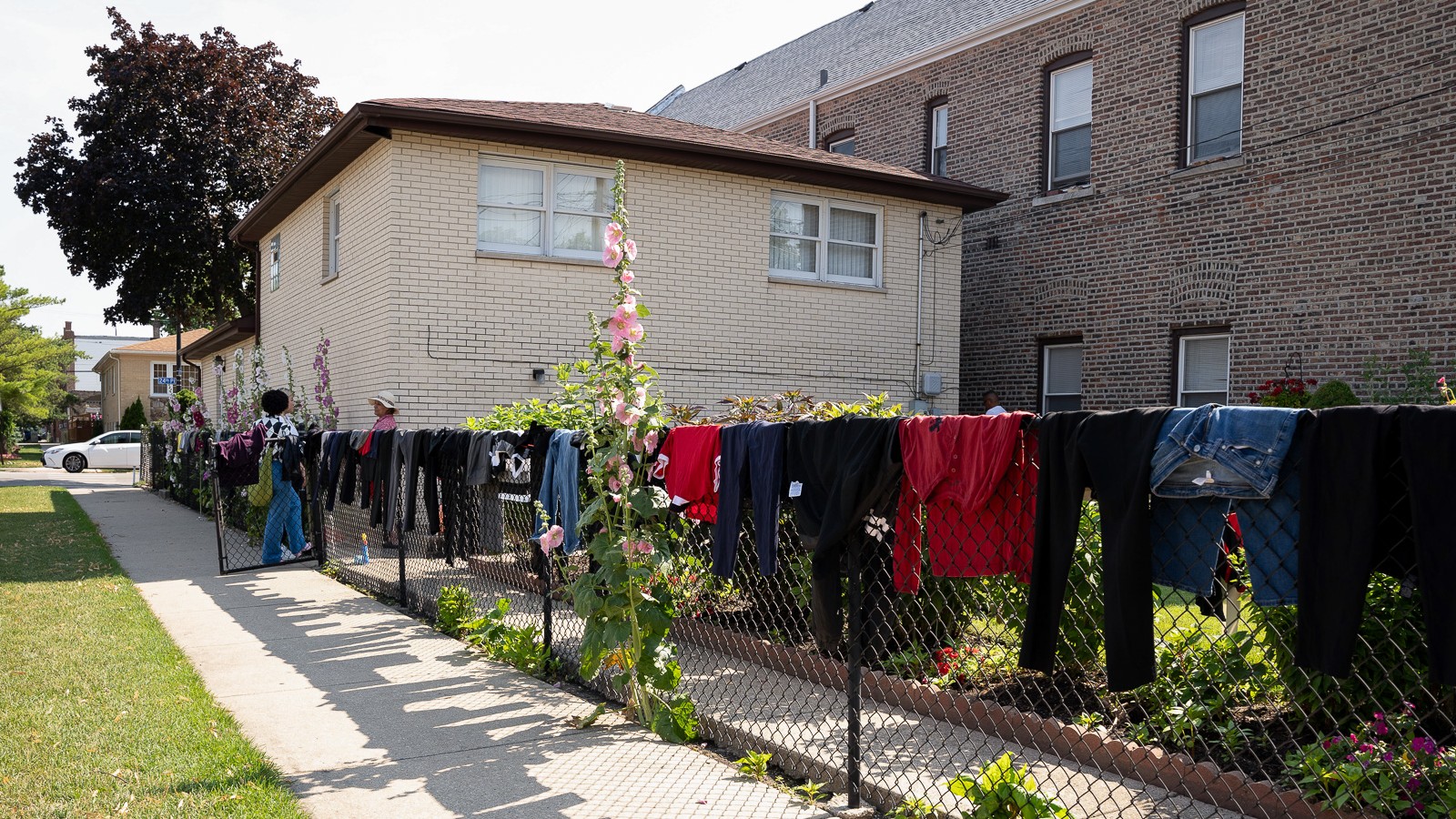 A wire fence outside of a house with clothes drying on top.