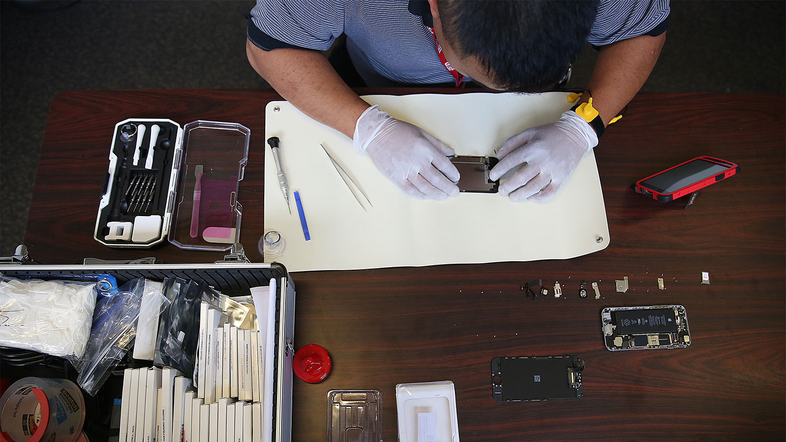 Overhead view of a man taking apart an iphone