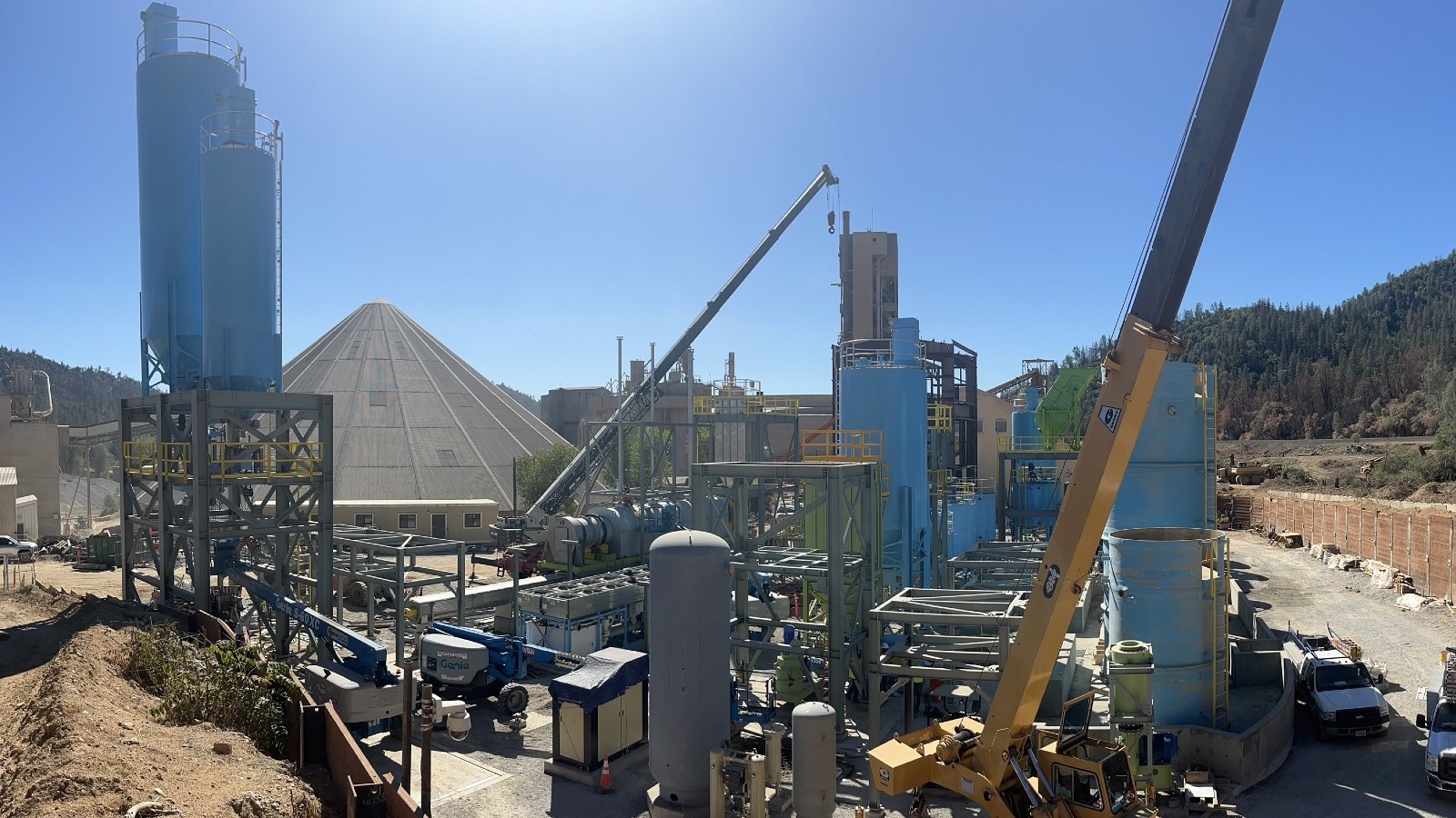 A mound of cement surrounded by industrial equipment.