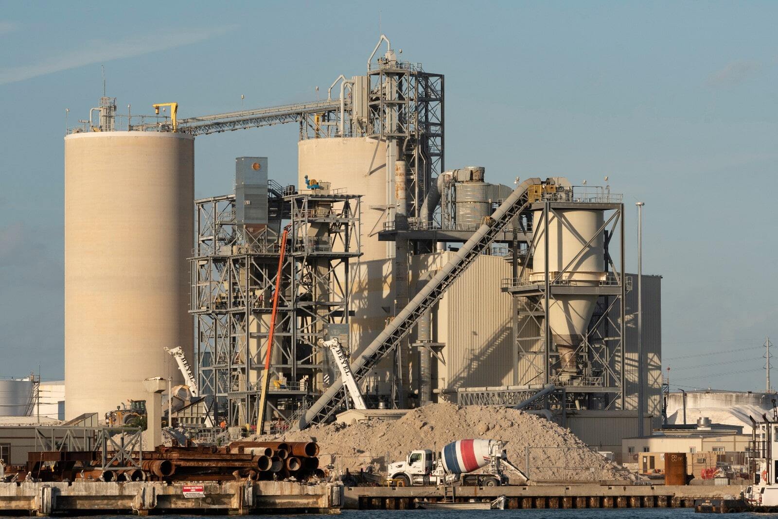 A large industrial facilitiy with a white truck in front of it.