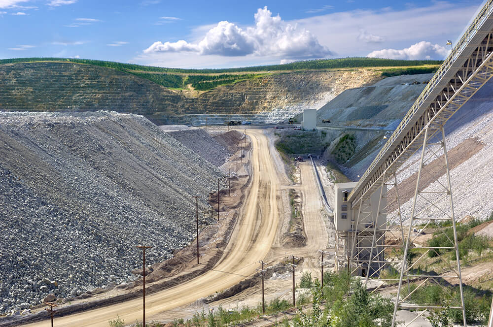 a valley with ridges and a large conveyer belt carrying rocks