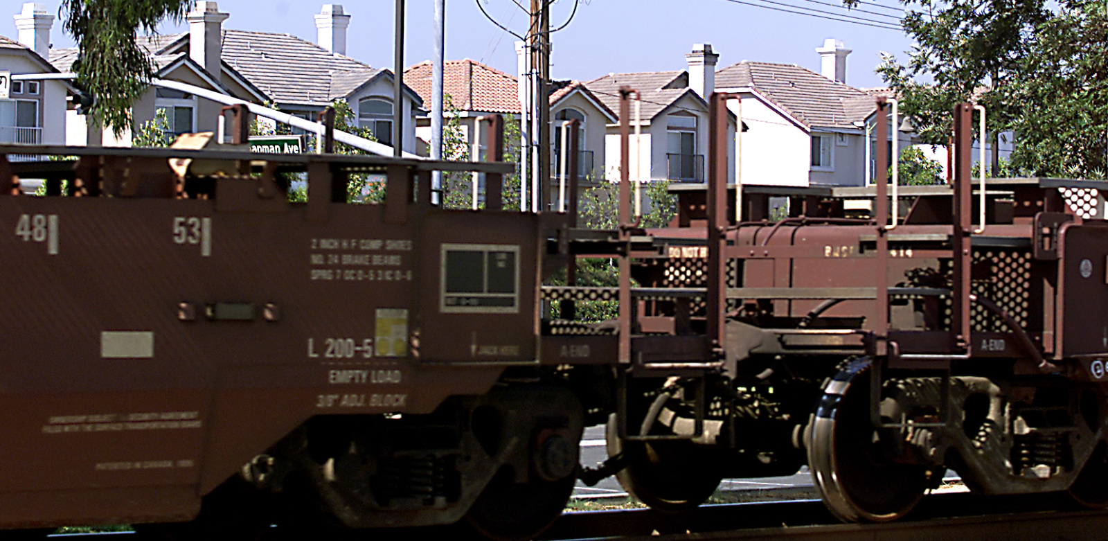 Photo of a train in motion obscuring the view of homes