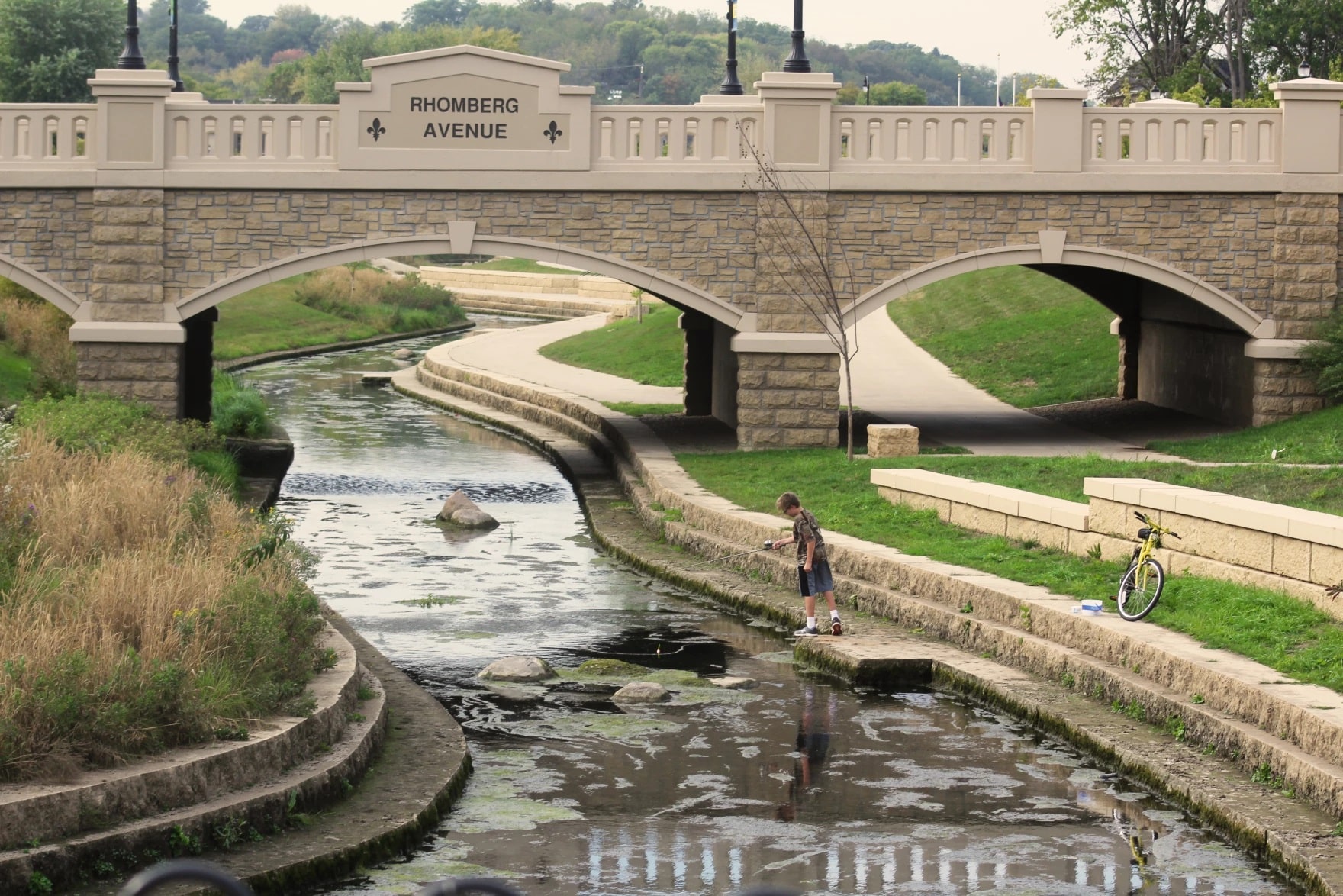 A stone bridge crosses over a creek.