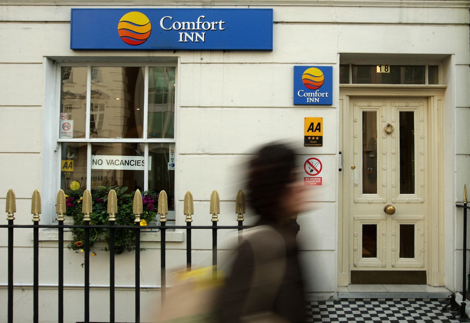 Comfort Inn sign with blurred person walking beneath