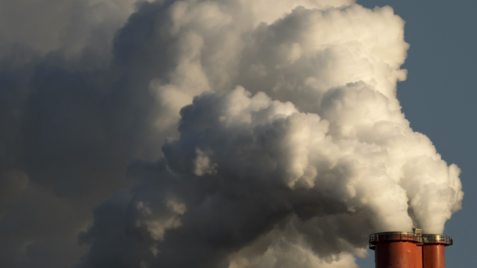 Emissions from a red smokestack