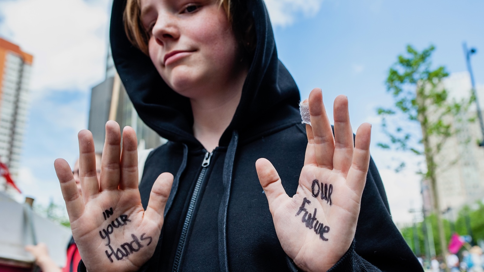 A boy shows the message 'In your hands, our future', written on his hands during the demonstration organized by Extinction Rebellion against the fossil fuel industry on May 19th, 2022.