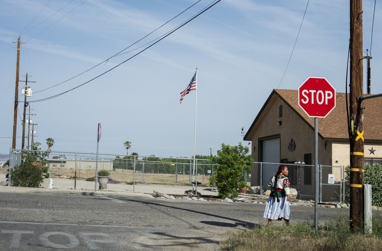 A woman crosses the street near a stop sign