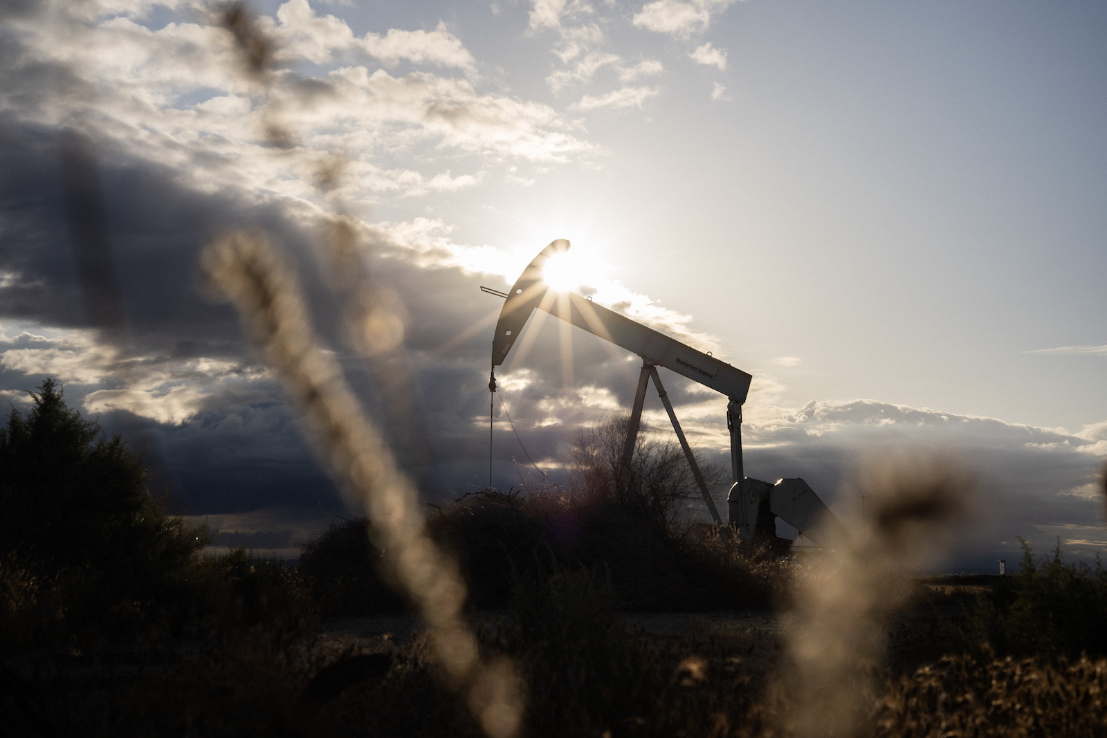 A pumpjack silhouetted against the sun