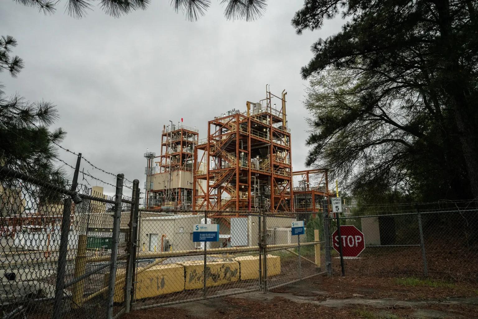 An industrial plant stands under a cloudy sky.