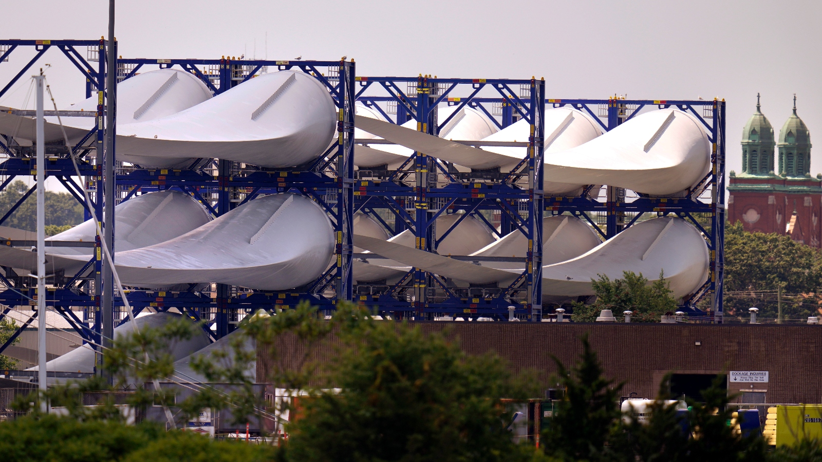 Wind turbine blades awaiting installation at an offshore wind farm are seen stacked on racks in a harbor in New Bedford, Massachusetts.