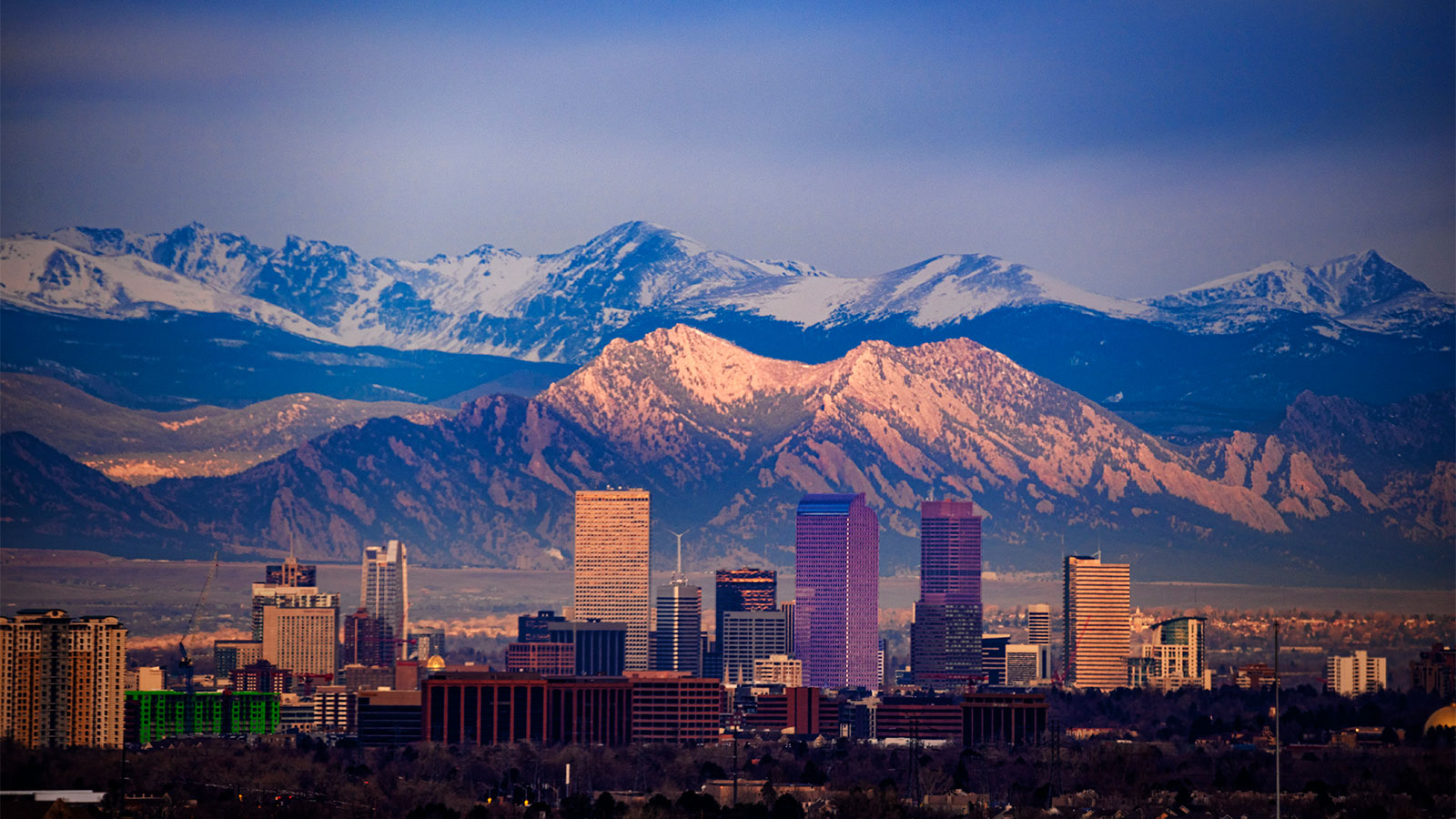 Cityscape of downtown Denver with the Flatirons and Longs Peak in the background from a drone perspective