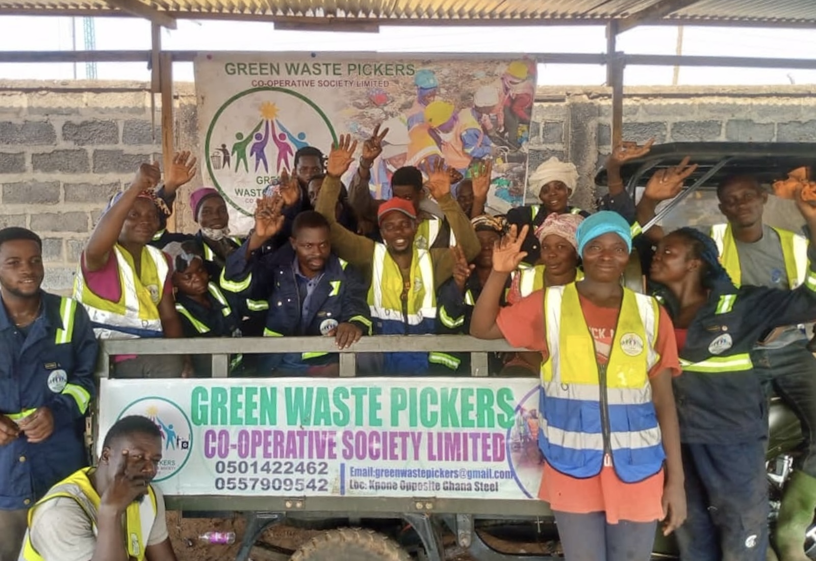 A group of people poses in front of a banner reading, "Green Waste Pickers Cooperative Society, Limited."